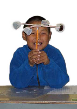 Photo: Student smiles from behind his hand-made anemometer